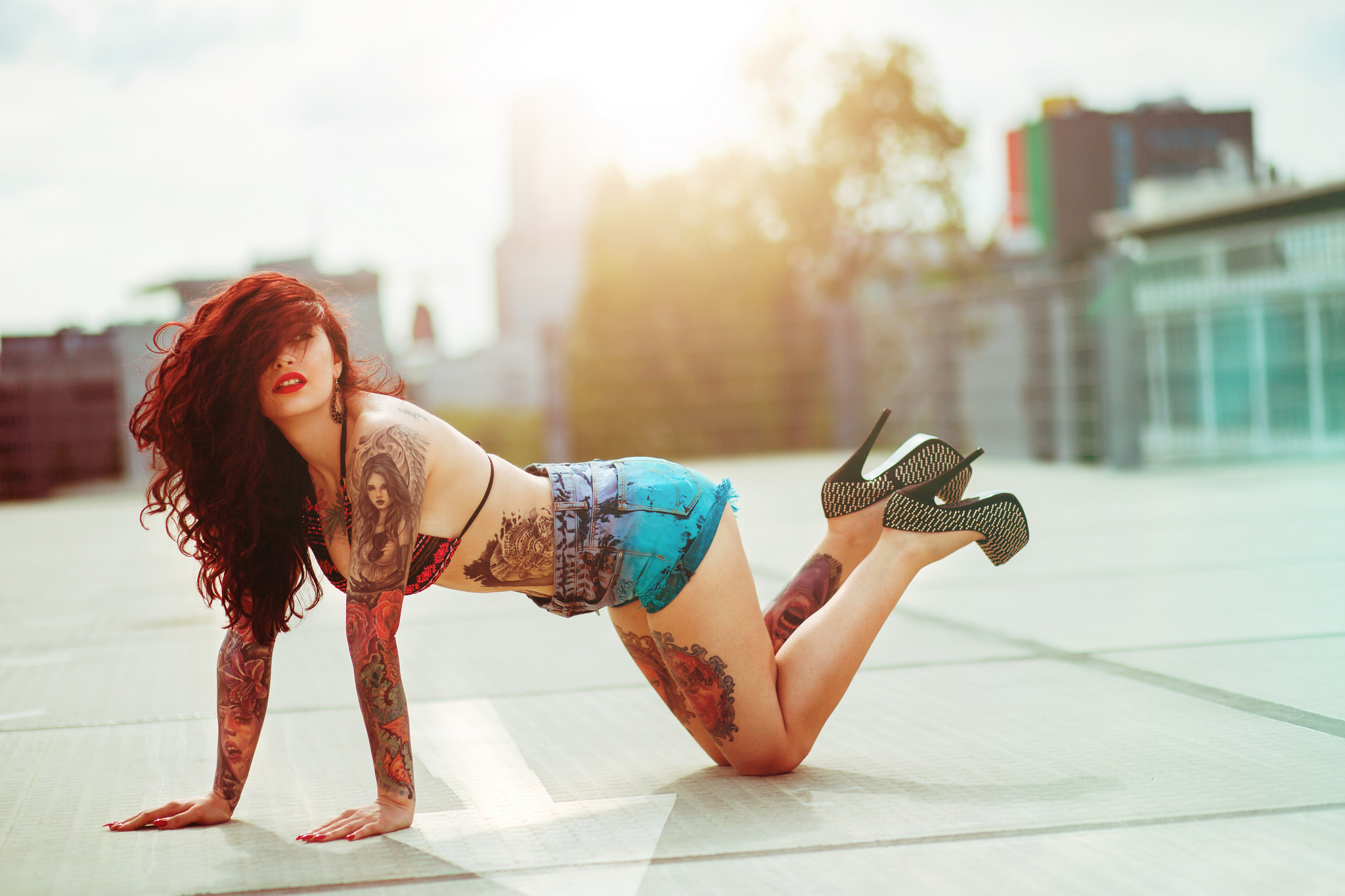 Красивая девушка с татуировками позирует в трусиках